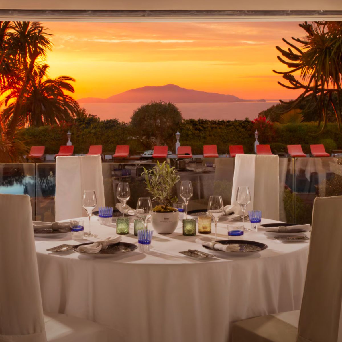 white table clothed circle table overlooking a sunset