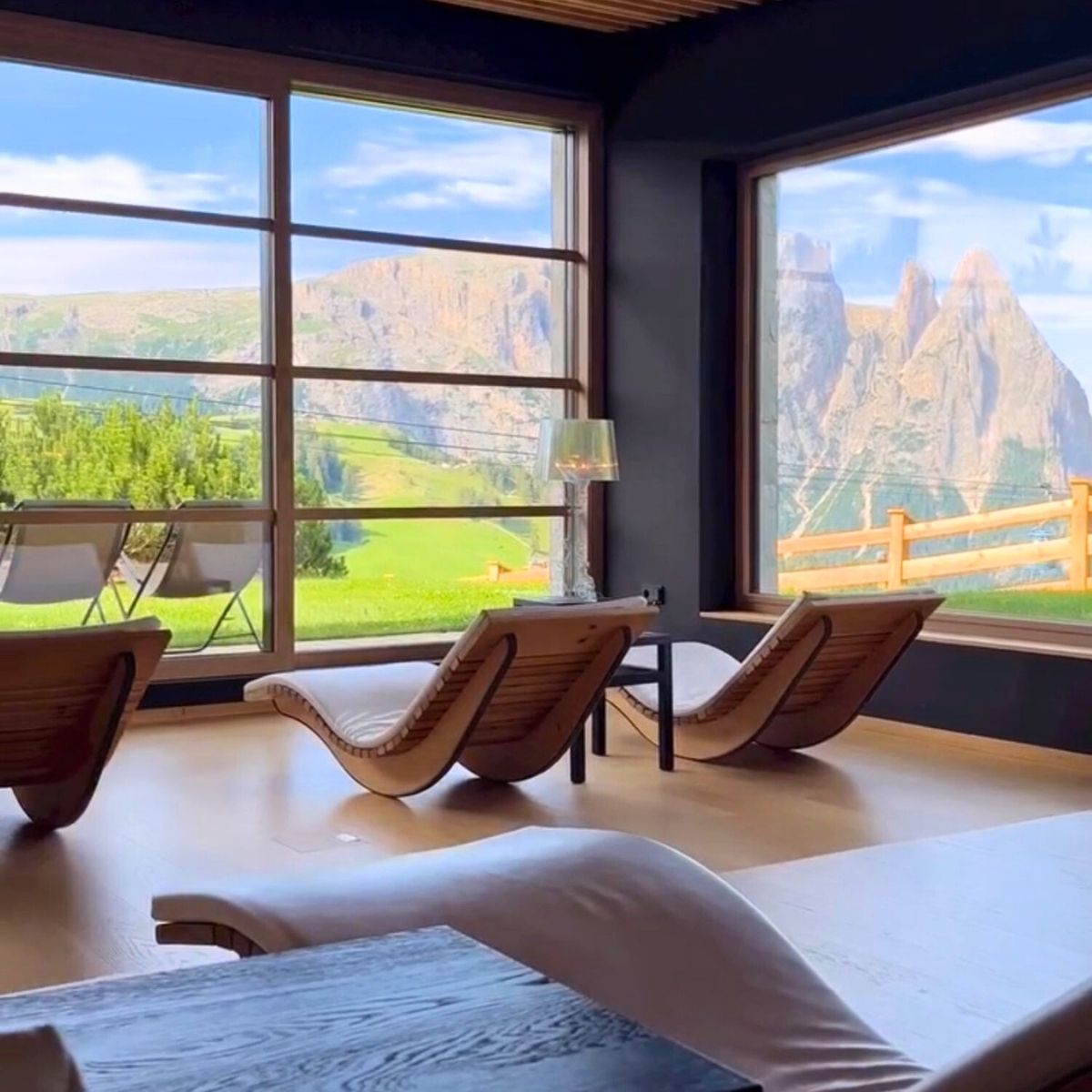spa chairs with windows showing the green dolomites mountain in the background