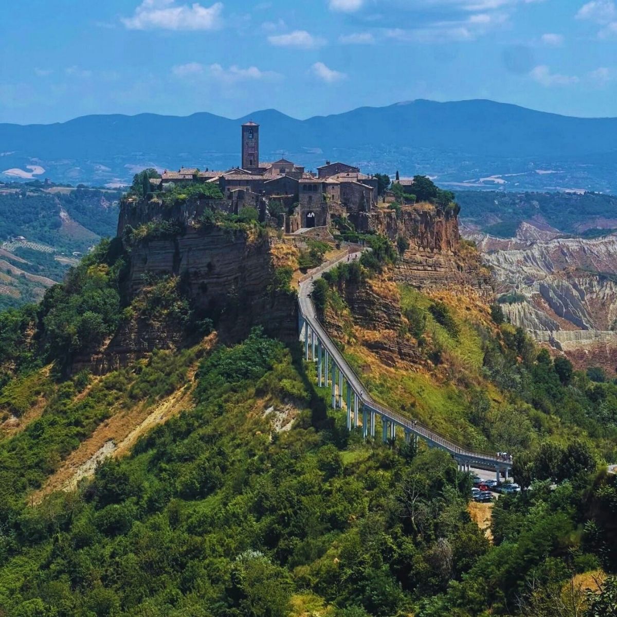old city on a cliff with clouds in the background