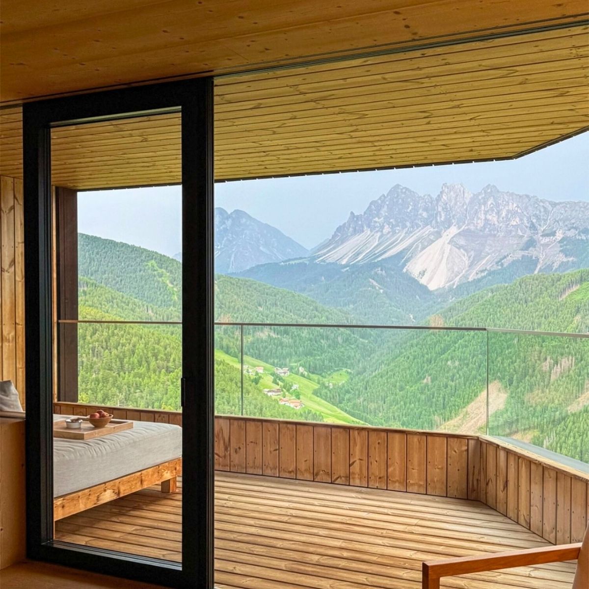 wooden balcony overlooking the green mountain tops in the dolomites