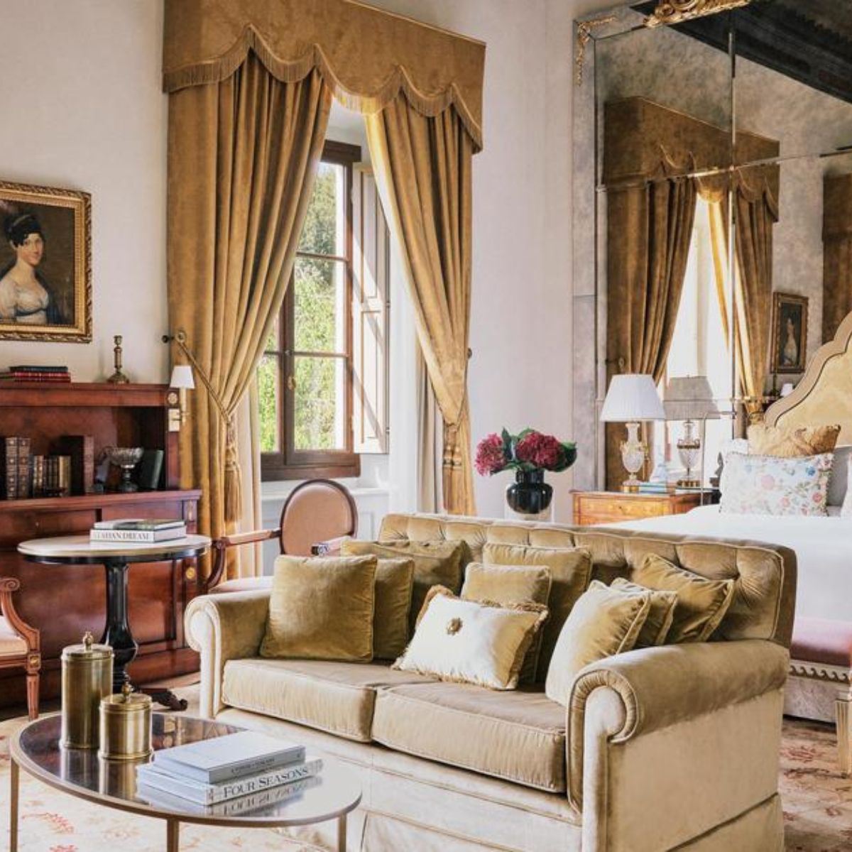hotel room with gold sofa and a large bed with a mirrored wall