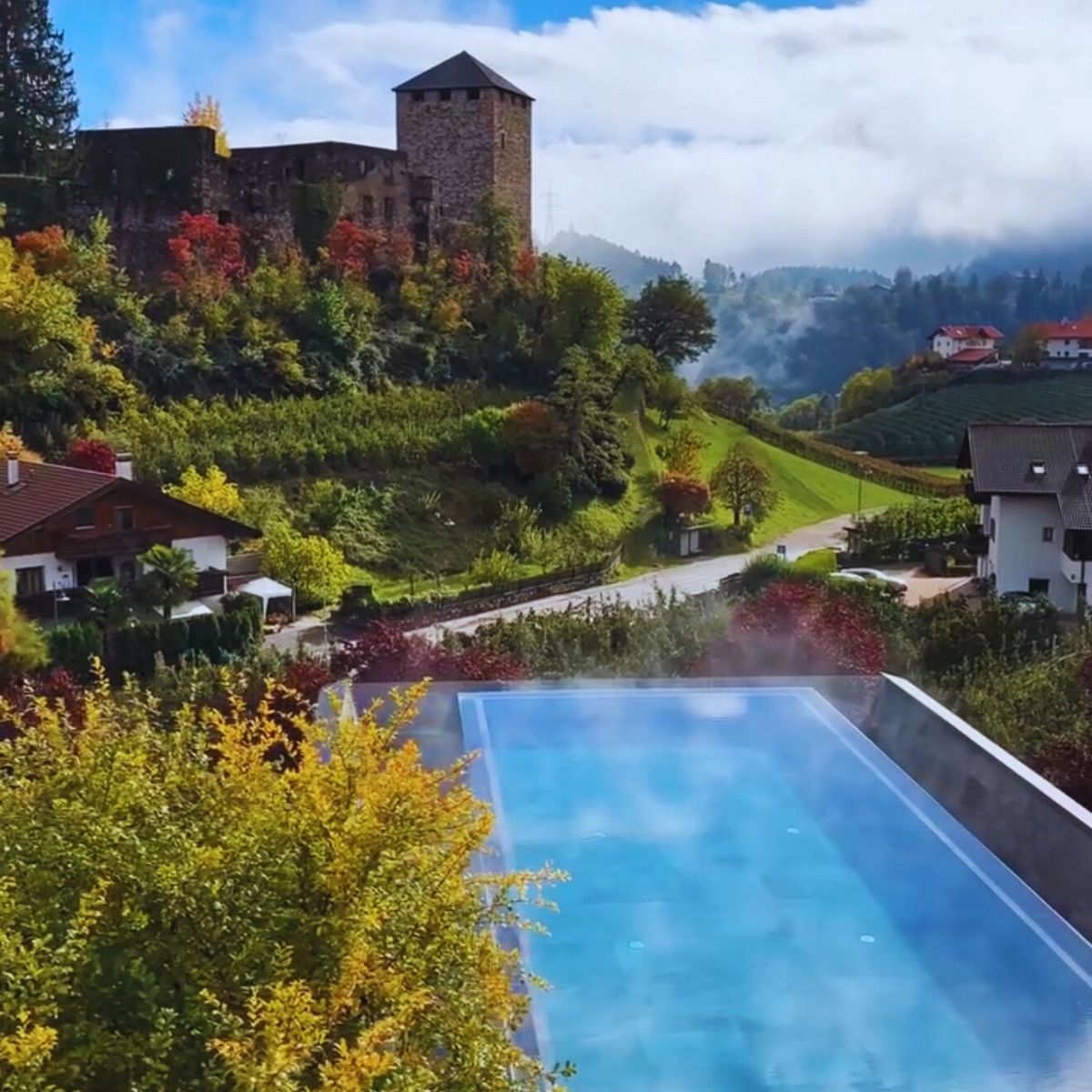 steaming swimming pool with castle and mountains in background
