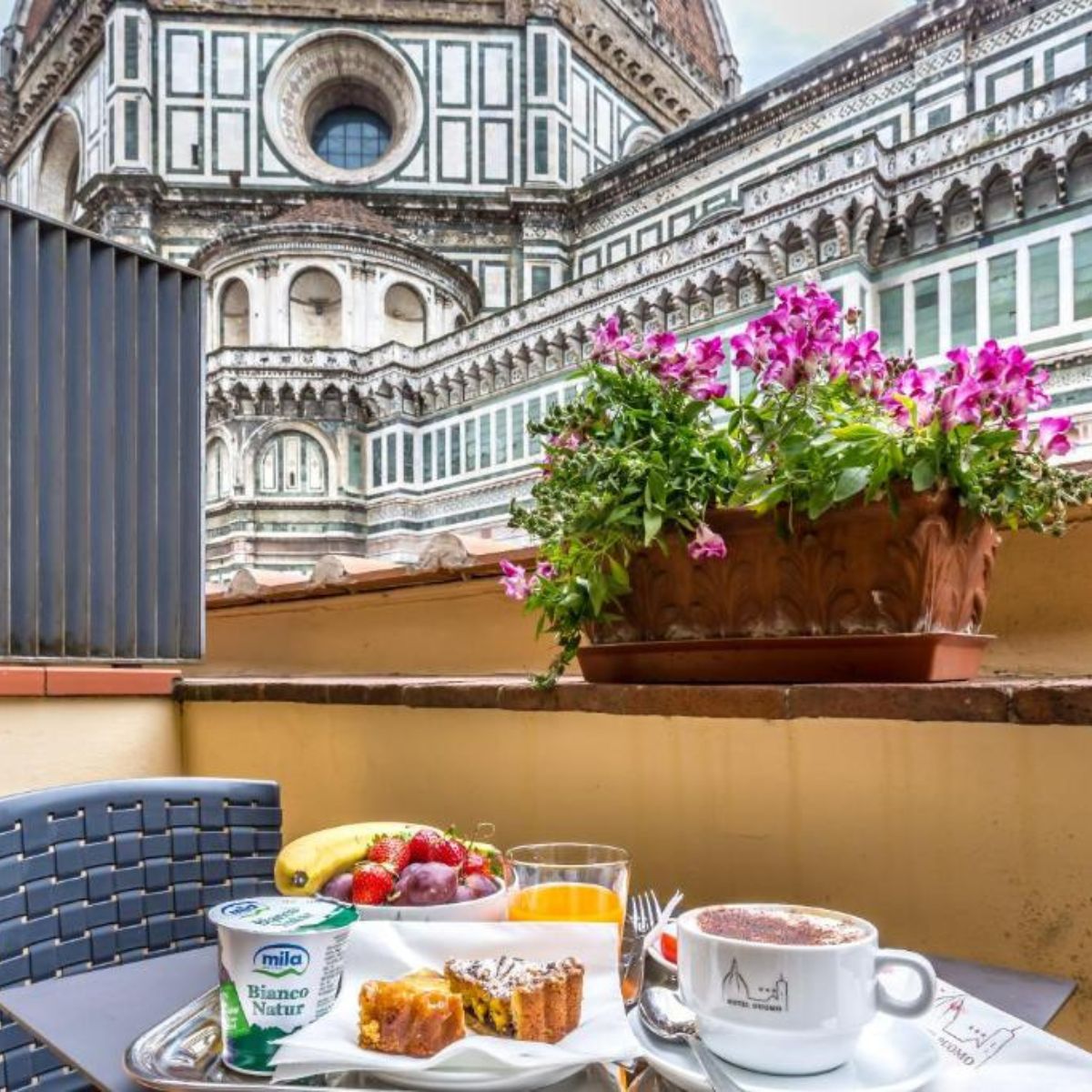 breakfast table on a patio with the Florence Duomo in the background