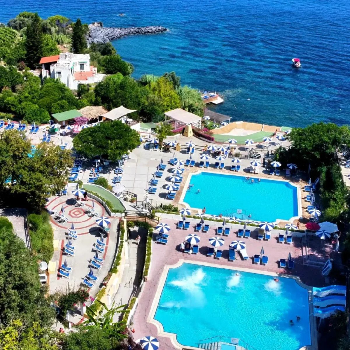 thermal pools surrounded by green trees and the sea