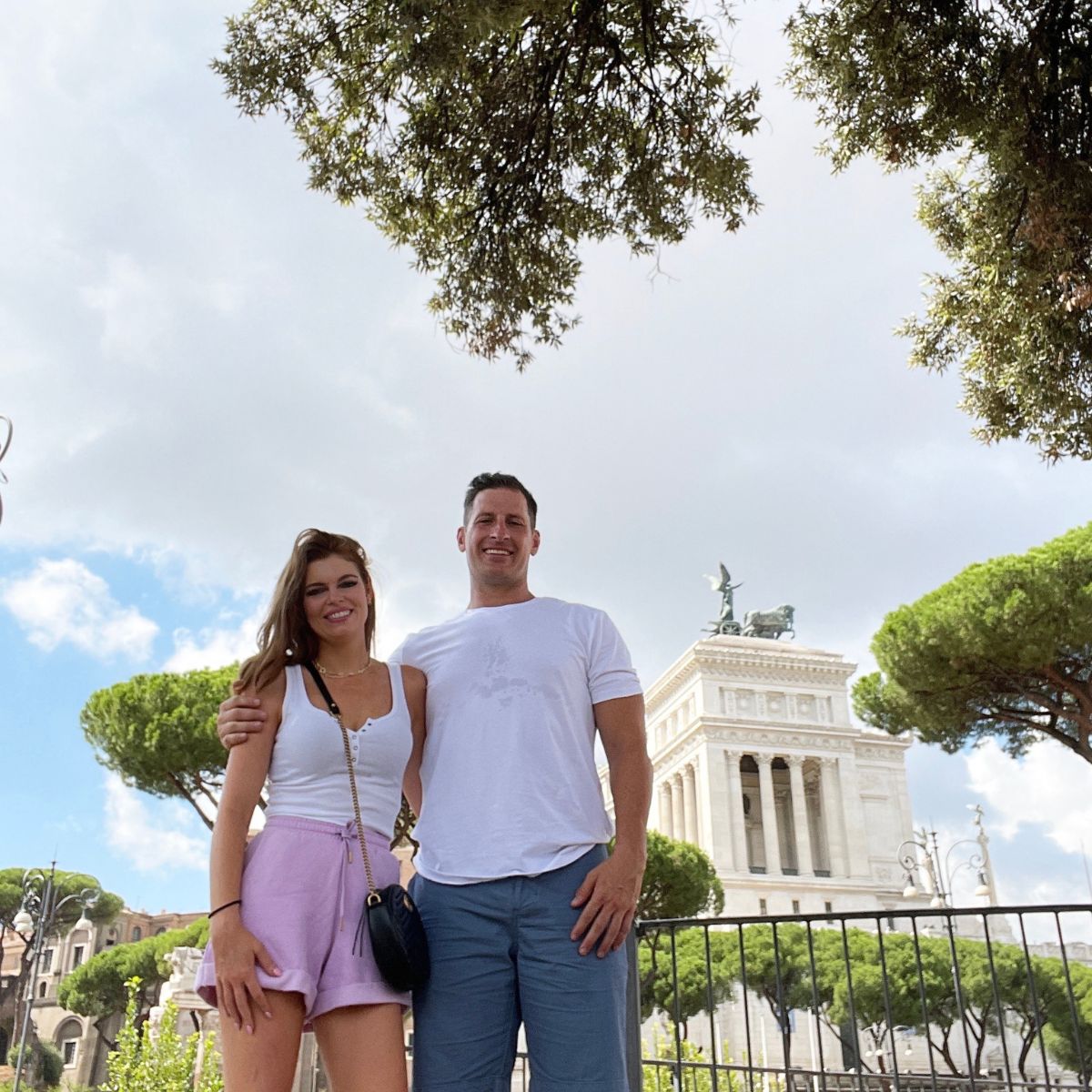 couple posing in front of white castle in rome