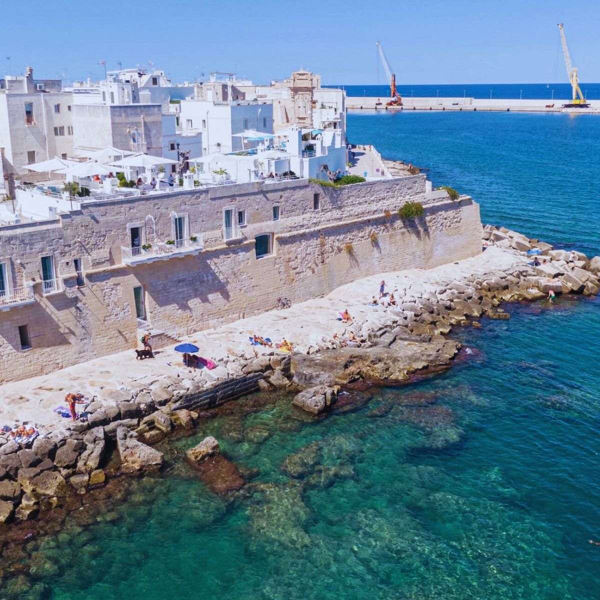 rocky sea edge with white buildings in the background
