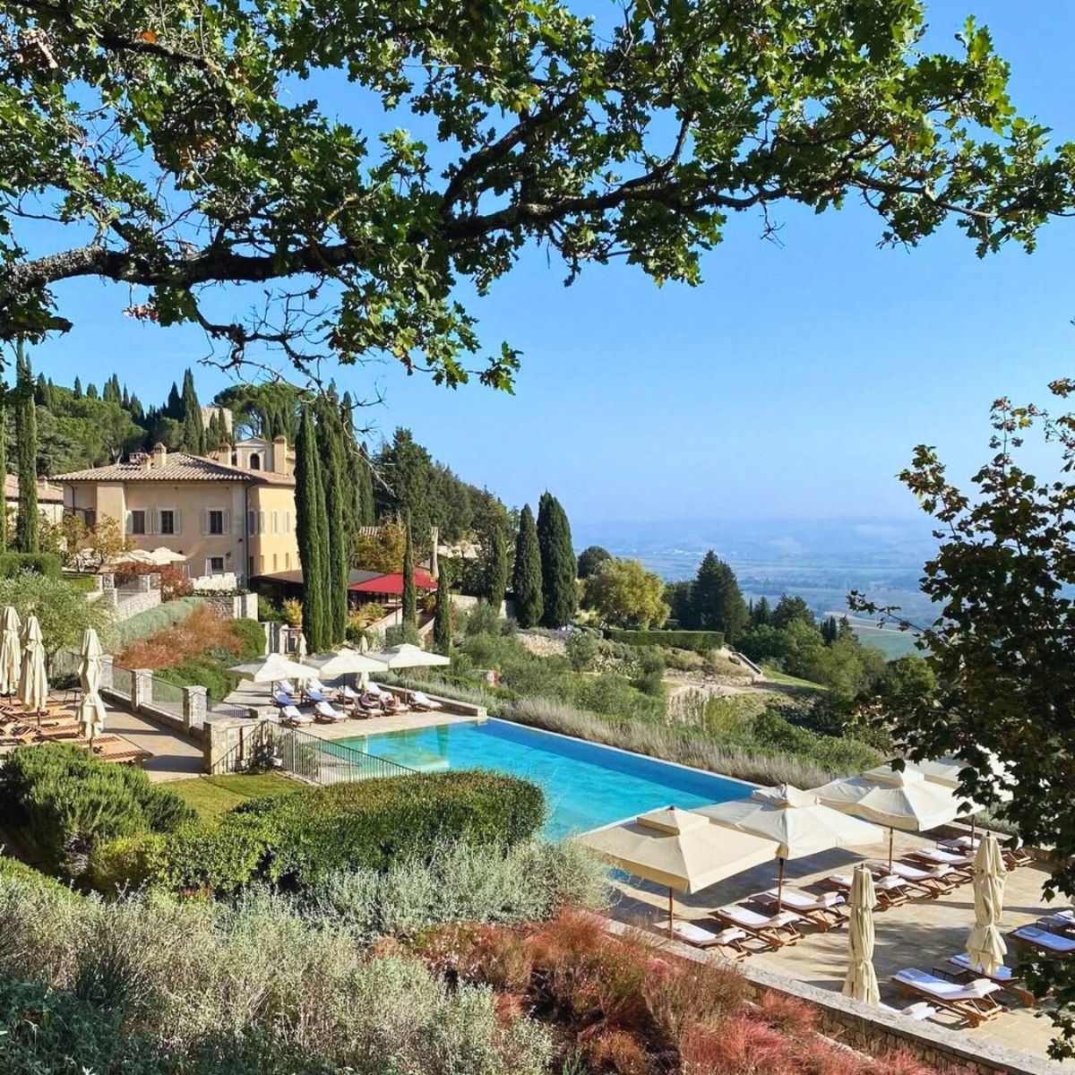 overhead shot of a pool in tuscany with a pool and stone building in the background