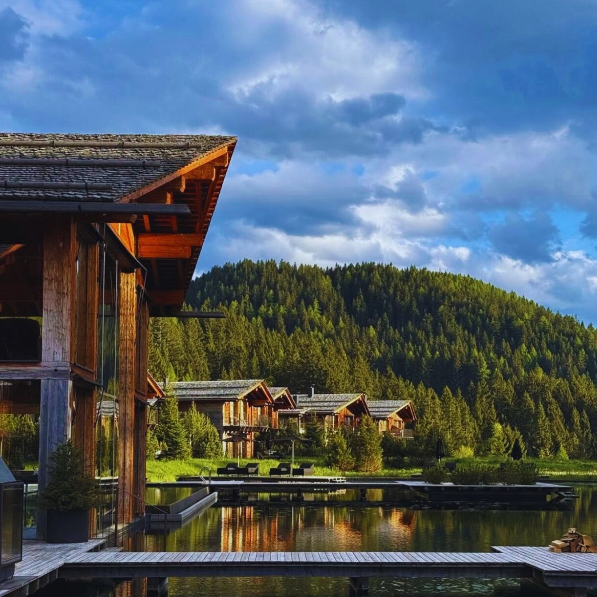 lodges surrounding a lake with mountains and blue skies in the background