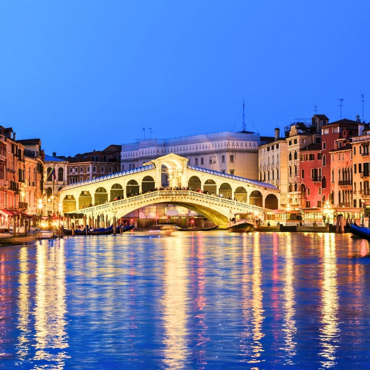 Rialto Bridge in Venice at night shimmering with light