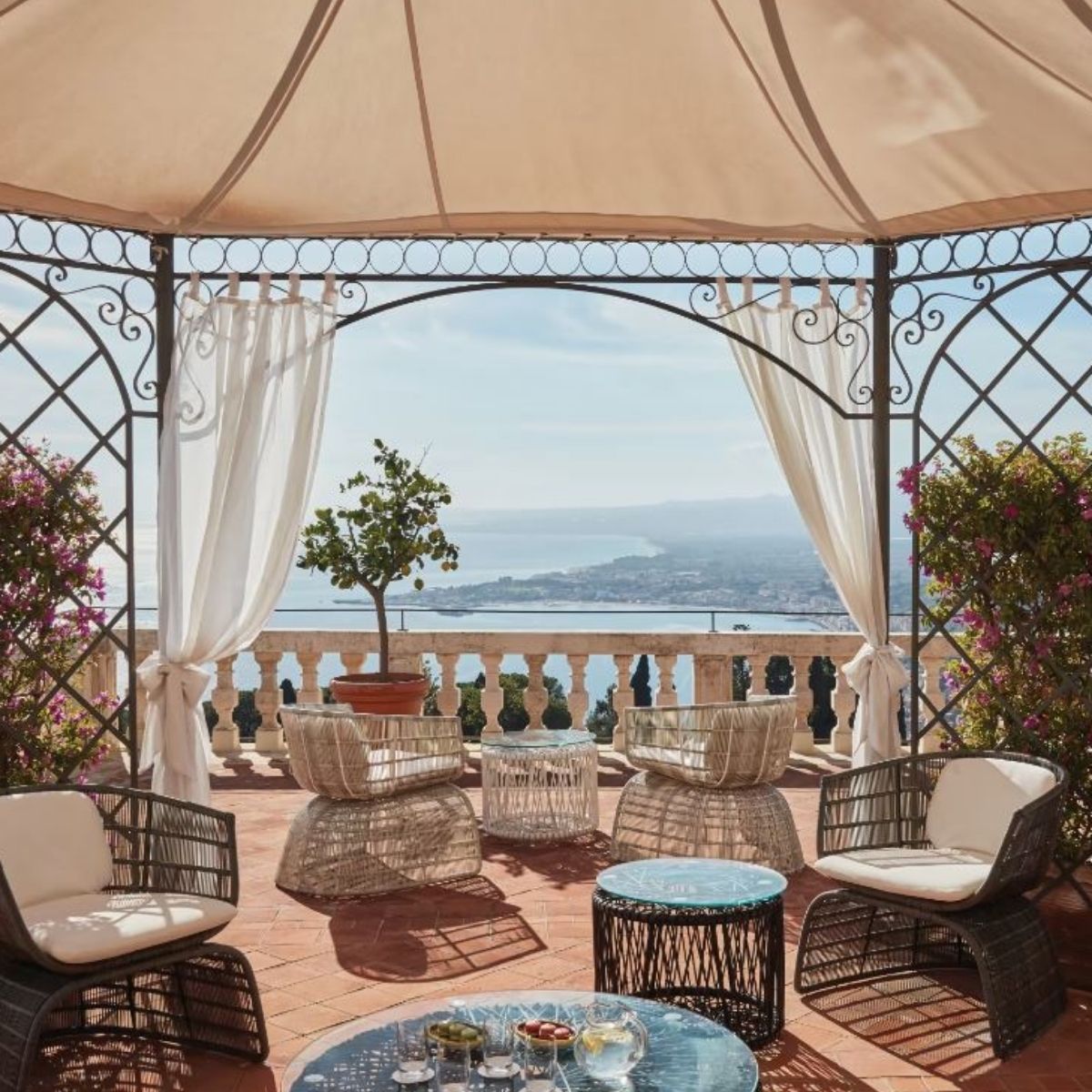 terracotta patio with sitting chairs overlooking the sea in taomina