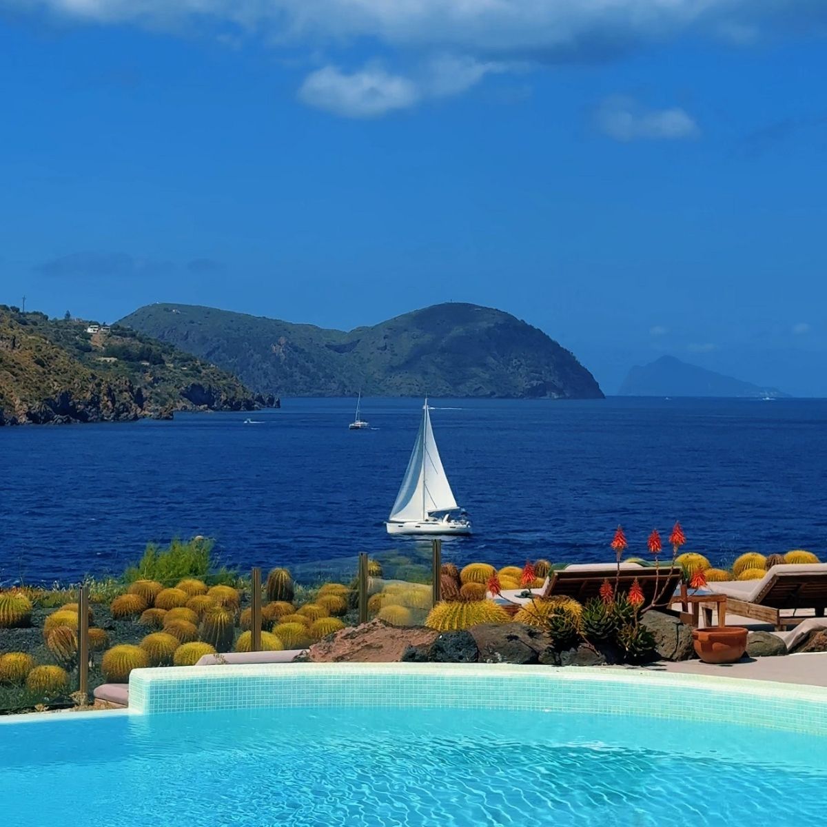 sail boat in the see with an pool and small cactus plants