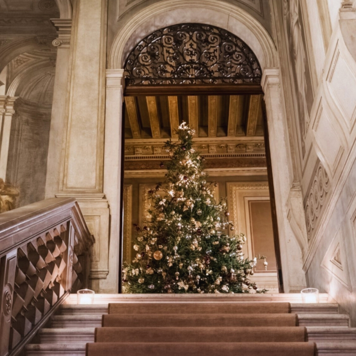 staircase in a palace with a christmas tree at the top of the stairs