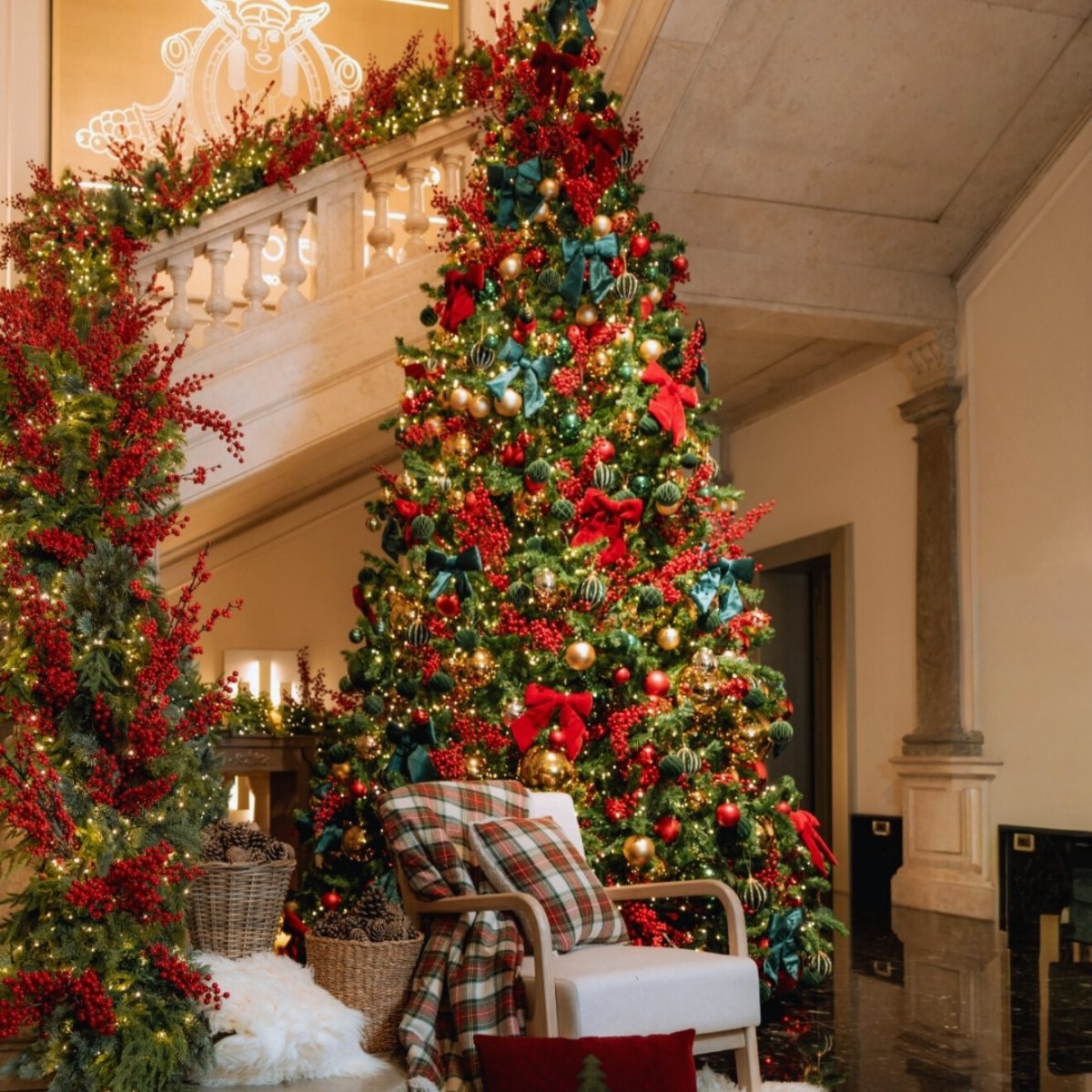 christmas tree with red bows in front a stairwell in a hotel lobby