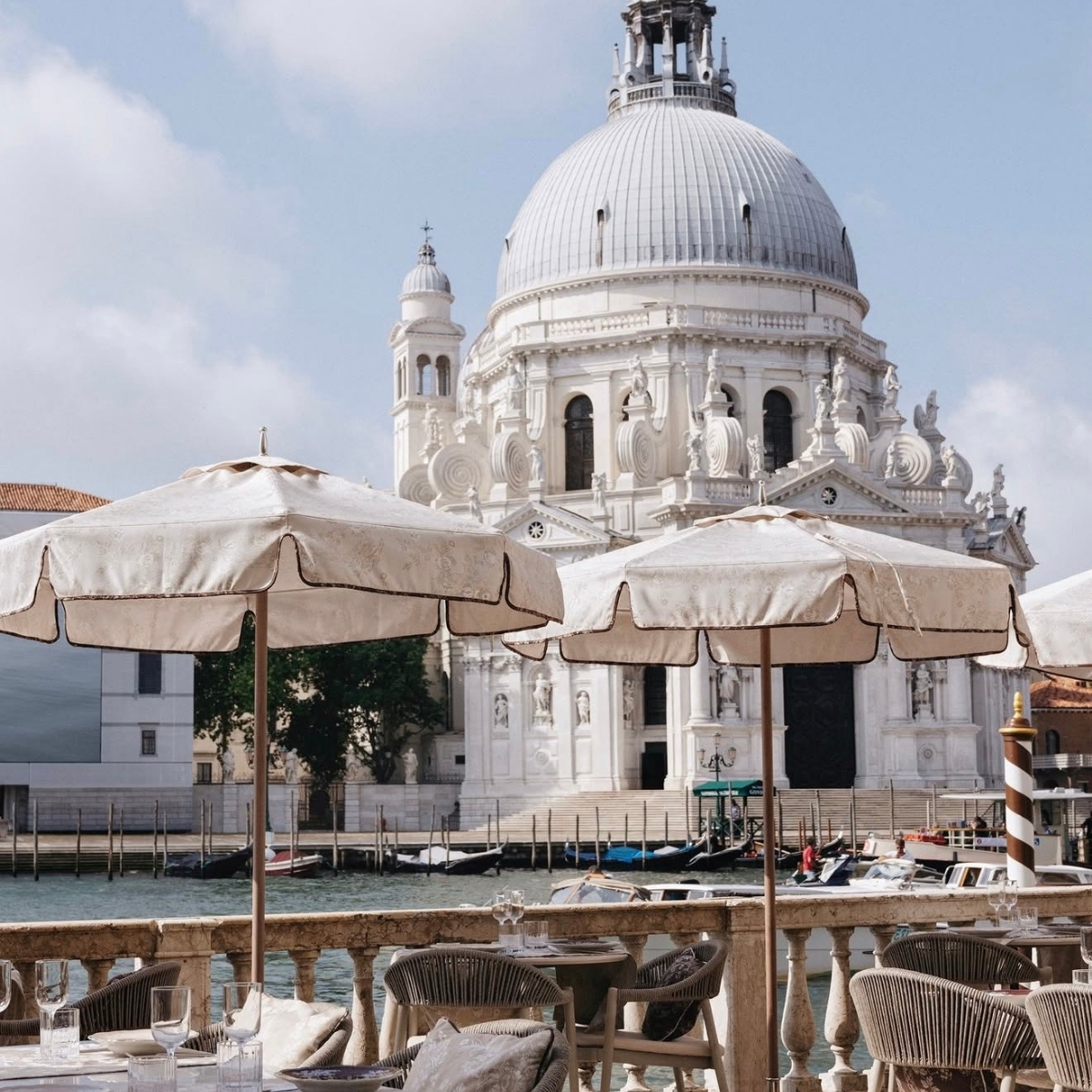 Scenic view of Venice church with outdoor seating and umbrellas at St. Regis Venice