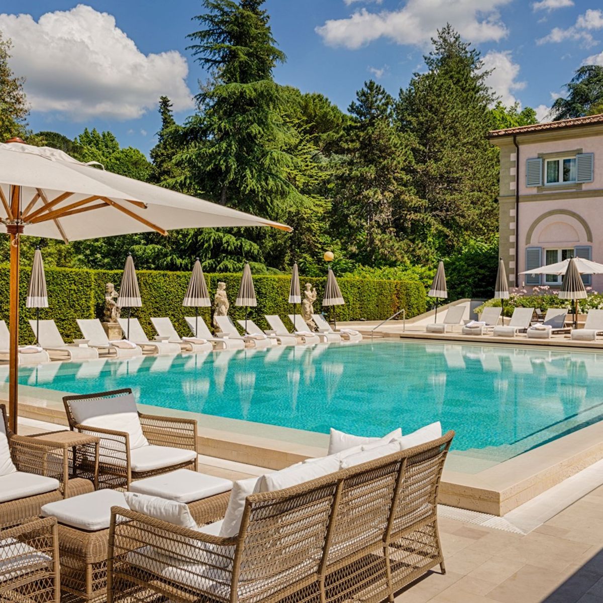 Villa Cora Florence swimming pool surrounded by hedges and stone building