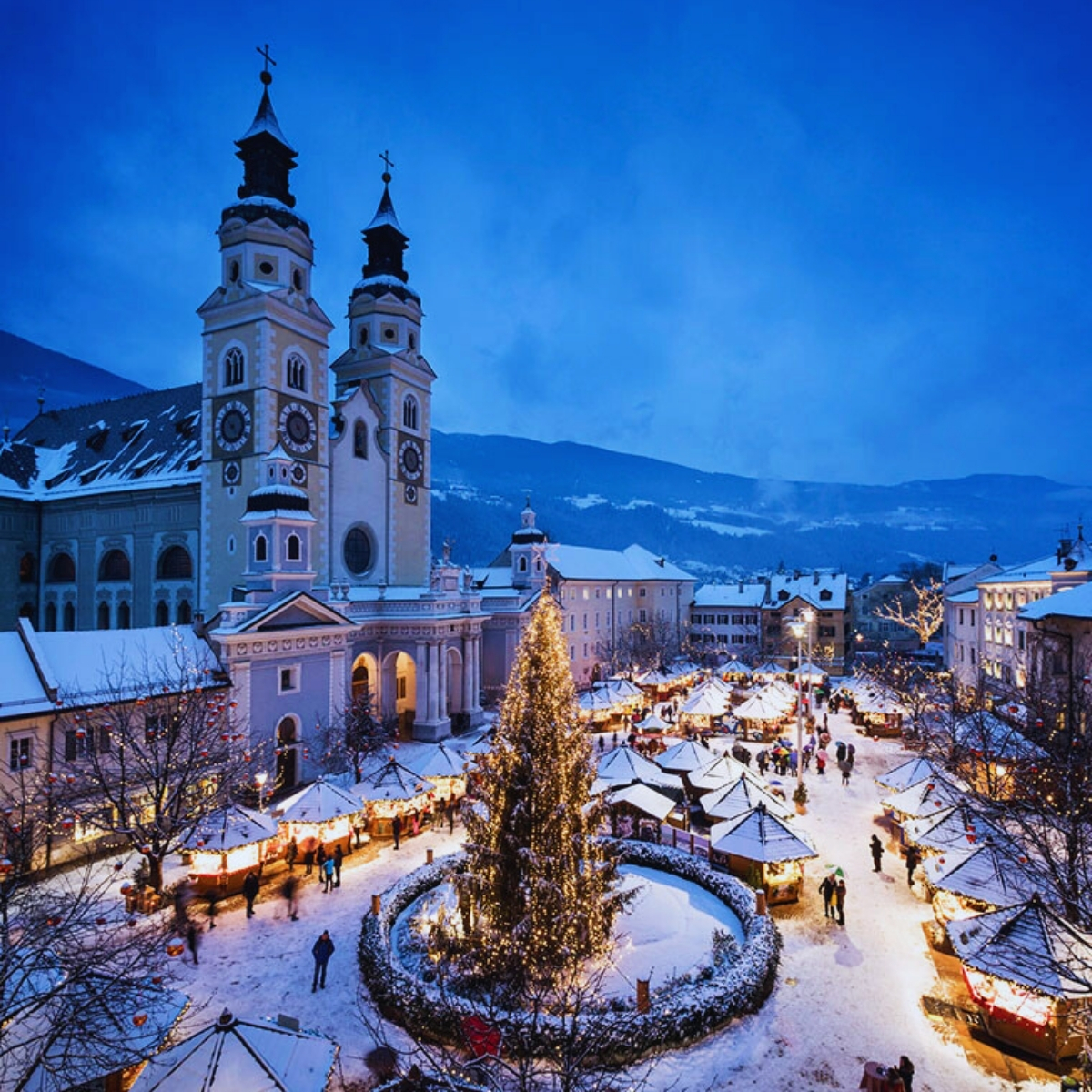 Italian old town covered in snow with Christmas tree in the square